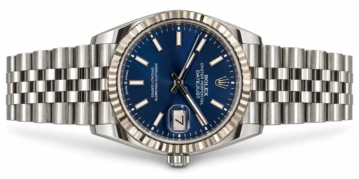 Blue-dial Rolex Datejust and Jubilee bracelet arranged horizontally on white