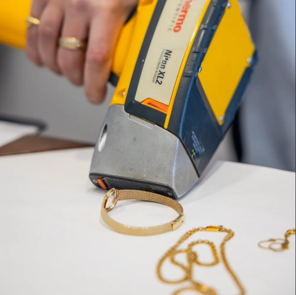 Gold jewelry being tested on a precious metal analyzer at San Diego Jewelry Buyers, showing the karat reading